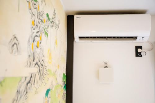a refrigerator next to a wall with a painting at Randor Residence Kyoto Nijo Castle in Kyoto