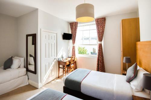 a hotel room with two beds and a window at The Regency, Clifton Bristol in Bristol