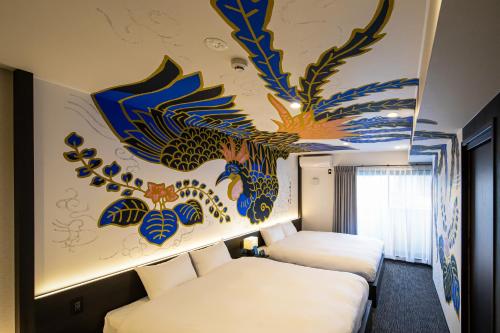 two beds in a room with a painting on the wall at Randor Residence Kyoto Nijo Castle in Kyoto