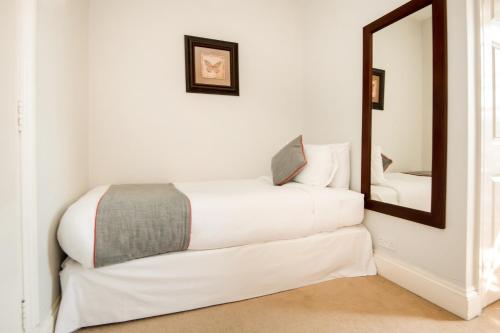 a bedroom with a white bed with a laptop on it at The Regency, Clifton Bristol in Bristol