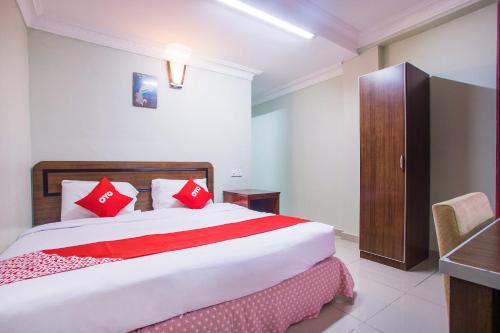 a bedroom with a large bed with red pillows at Hotel O Casavilla Hotel in Batu Caves