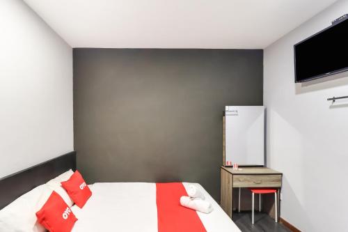 a bedroom with a bed and a tv on a wall at OYO 89381 Moonnight Hotel in Batu Caves
