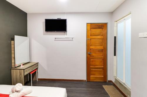 a room with a mirror and a tv on the wall at OYO 89381 Moonnight Hotel in Batu Caves