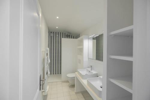 une salle de bain blanche avec des toilettes et un lavabo dans l'établissement Près d'Avignon élégante villa avec vue, à Pujaut