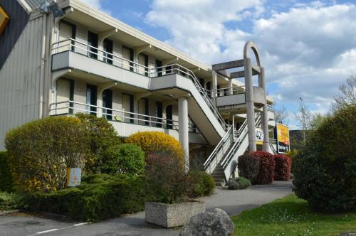 a building with a spiral staircase in front of it at Premiere Classe Chambery in Chambéry