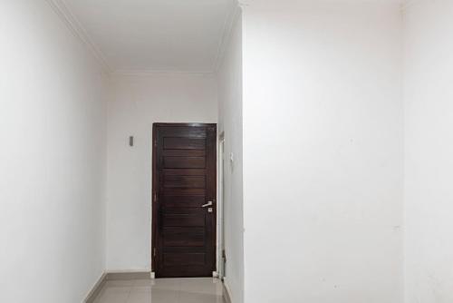 a hallway with a wooden door in a room at Hotel O Kambang Iwak Area Near Kambang Iwak Park Formerly Kerangga in Palembang