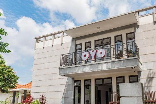 a white building with a balcony at Hotel O Kambang Iwak Area Near Kambang Iwak Park Formerly Kerangga in Palembang