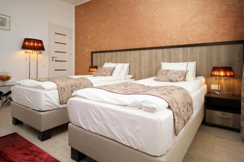 due letti in una camera d'albergo con due lampade di Studio Old Town a Bucarest