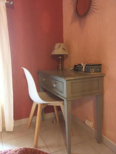 un bureau avec une chaise et une lampe. dans l'établissement Tramontane chambre salon et piscine, à Jonquerettes