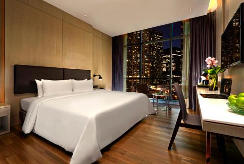 a bedroom with a large white bed and a desk at VE Hotel & Residence in Kuala Lumpur