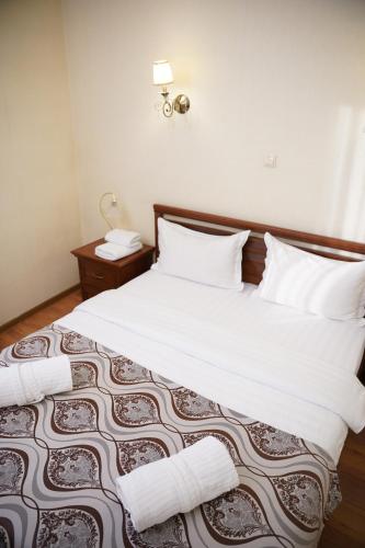 a bedroom with a bed with white sheets and pillows at Sultan Beibarys in Astana