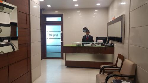 a man sitting at a desk in a lobby at Bentley Hotel Marine Drive in Mumbai