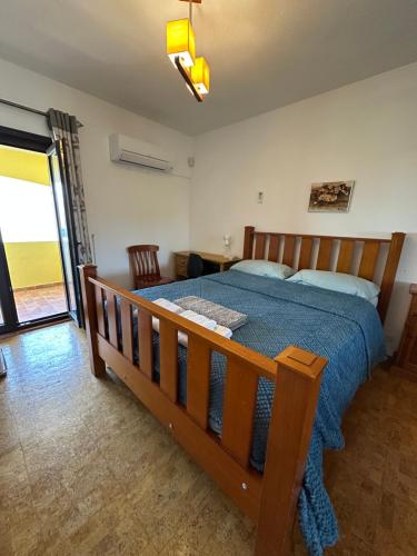 - une chambre avec un lit en bois et une couette bleue dans l'établissement Casa Amarela, à Faro