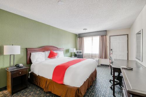 a hotel room with a large bed and a desk at OYO Hotel Rosenberg TX I-69 in Rosenberg