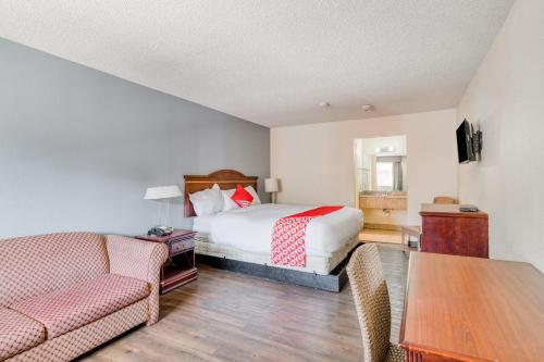a bedroom with a bed and a couch and a table at OYO Hotel Rosenberg TX I-69 in Rosenberg