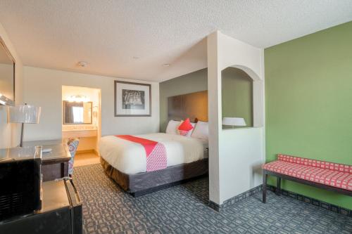 a hotel room with a bed and a desk at OYO Hotel Rosenberg TX I-69 in Rosenberg