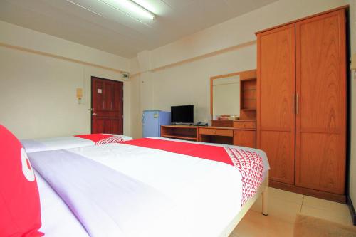 a bedroom with a bed and a dresser and a mirror at Ok Home Airport in Bangkok