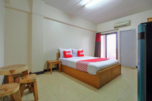 a bedroom with a bed with red pillows on it at Ok Home Airport in Bangkok