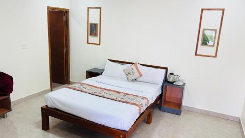 a bedroom with a bed and two night stands at Hidden doors apartment in Ooty