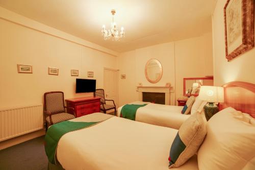 a hotel room with two beds and a television at OYO Bailbrook Lodge, Bath in Bath