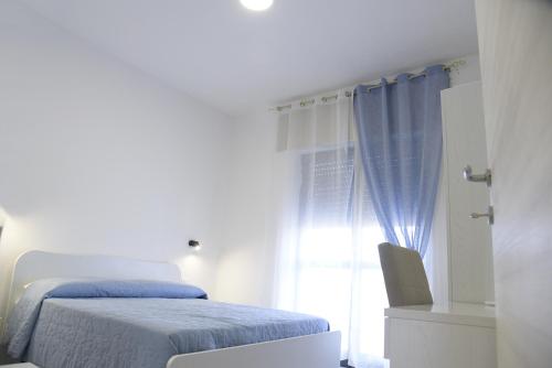 a white bedroom with a bed and a window at Prestige Affittacamere Paestum in Stazione di Paestum