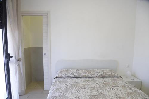 a white bedroom with a bed with a white bedspread at Prestige Affittacamere Paestum in Stazione di Paestum