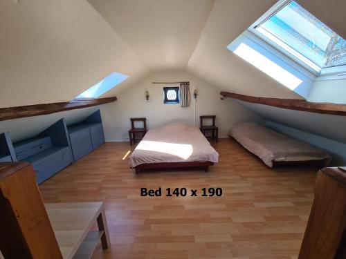 a attic room with a bed and two windows at Gîte Charolais Burgundy in Mont-et-Marré