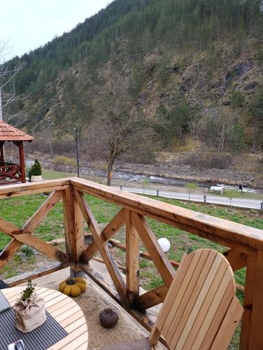a wooden deck with a chair and a table at Dedin Konak in Mokra Gora