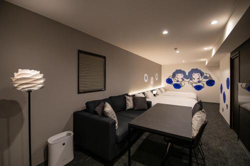 a room with a couch and a bed and a table at Randor Residence Kyoto Nijo Castle in Kyoto