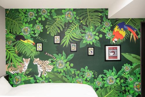 a bedroom with a green wall with drawings of jungle at Randor Residence Kyoto Nijo Castle in Kyoto