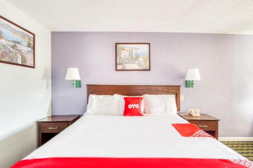 a hotel room with a large bed with a red pillow at OYO Hotel Channelview I-10 in Channelview