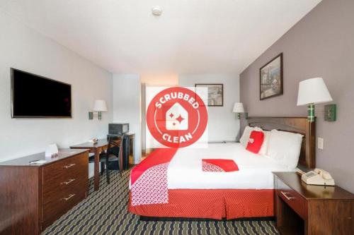 a hotel room with a bed with a sign on it at OYO Hotel Channelview I-10 in Channelview