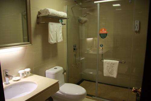 uma casa de banho com um chuveiro, um WC e um lavatório. em GreenTree Inn Zhejiang Ningbo Dongqian Lake Yinxian Avenue North Mozhi Road Business Hotel em Ningbo