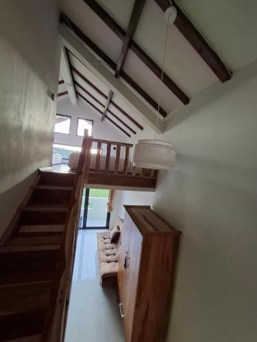 a room with a staircase and a living room with a couch at Mini Ricefilds rooms in Batukaras