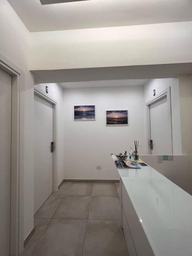 a kitchen with white walls and a white counter at Porta sul Mare in Tropea