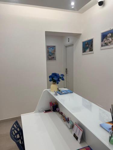 a white room with a white counter with a table at Porta sul Mare in Tropea