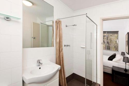 a white bathroom with a sink and a shower at Cunningham Terrace 1 in Perth