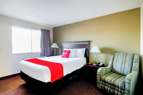 a hotel room with a large bed and a chair at OYO Hotel Eloy Casa Grande near I-10 in Eloy