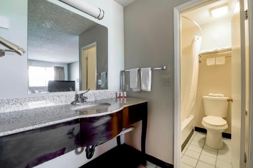 a bathroom with a sink and a toilet and a mirror at OYO Hotel Eloy Casa Grande near I-10 in Eloy