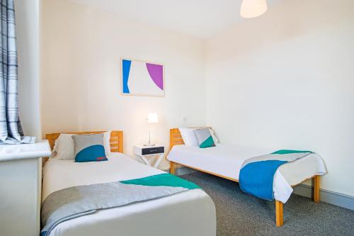 two twin beds in a room with at OYO The Green Man Pub And Hotel in London