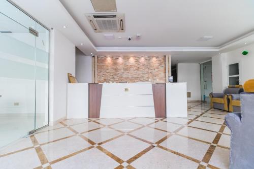 a living room with a tile floor and a brick wall at Super OYO 106 Muscat Grand Hotel Apartment in Seeb