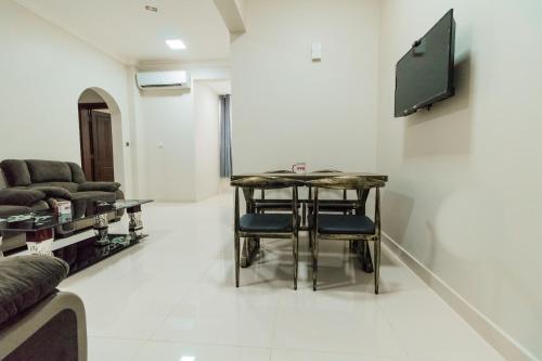 a living room with a table and chairs and a couch at Super OYO 106 Muscat Grand Hotel Apartment in Seeb