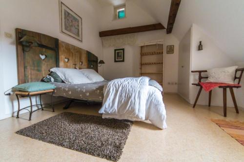 une chambre avec un lit avec des draps blancs et un tapis dans l'établissement Gite l'Ame d'Antan, à Colmar
