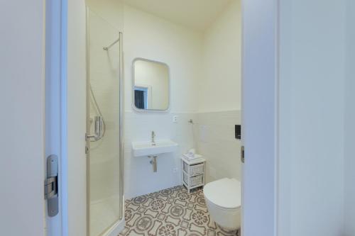 a white bathroom with a toilet and a sink at Shone apartment old town 2 bedroom in Bratislava