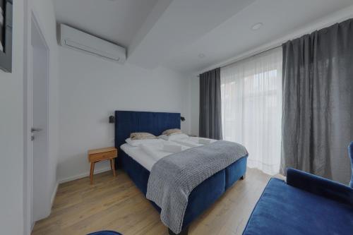 a bedroom with a blue bed and a window at Shone apartment old town 2 bedroom in Bratislava