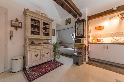 une cuisine avec un grand meuble en bois dans une pièce dans l'établissement Gite l'Ame d'Antan, à Colmar