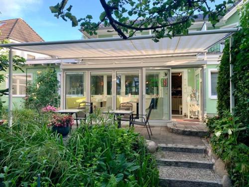 een afgeschermde veranda met een tafel en stoelen bij Pension Inselparadies Zingst in Zingst