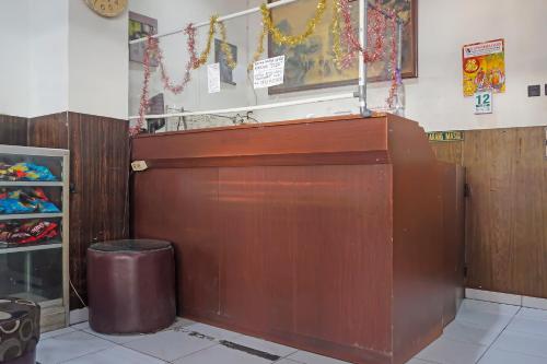 a large wooden door in a store with a trash can at Hotel O Diamond Inn Makassar in Makassar