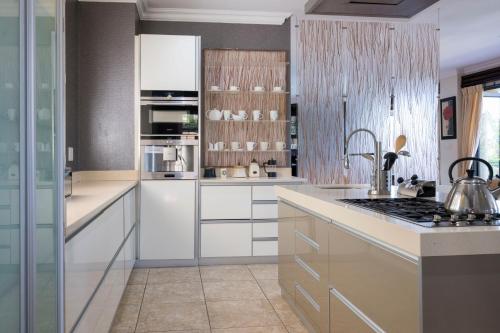 a kitchen with white cabinets and a sink at Marion Views in Ballito