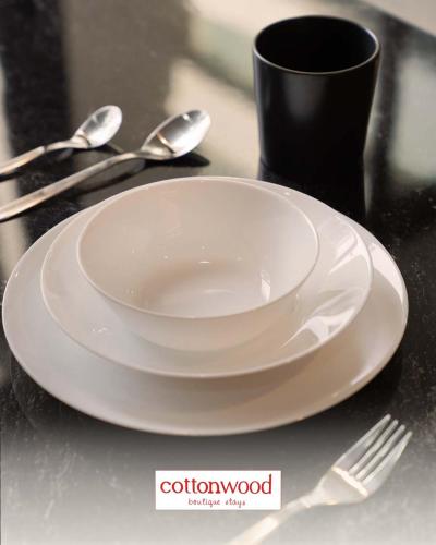 a white plate and a fork and spoon on a table at Cottonwood Yaputa Heated-Onsen Netflix Api-Unggun Karaoke PS4 in Sampal 2